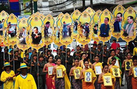 This picture taken on September 17, 2016 shows people holding images of Thailand's King Bhumibol Adulyadej at a parade during the "Khong Dee Muang Nara" (Good Products of Narathiwat) festival in Thailand's southern province of Narathiwat. / AFP / MADAREE TOHLALA (Photo credit should read MADAREE TOHLALA/AFP/Getty Images)